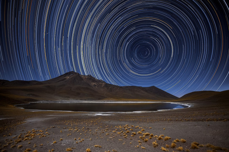 Figura 2. - Tutte le stelle del cielo notturno sembrano girare intorno ai due poli celesti (in questa foto, il polo sud). Queste fotografie, chiamate “star-trails”, vengono ottenute fotografando il cielo in time-lapse nell'arco di diverse ore.